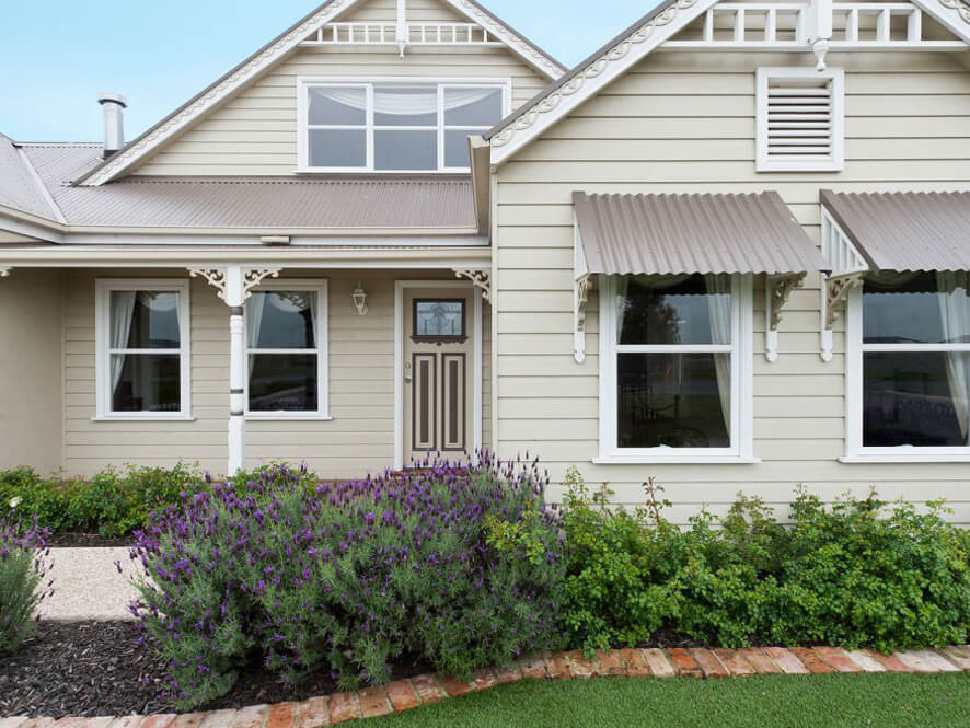 Cream Weatherboard with White Gable Fretwork and Window Trims with Lavender Garden Pebble Walkway